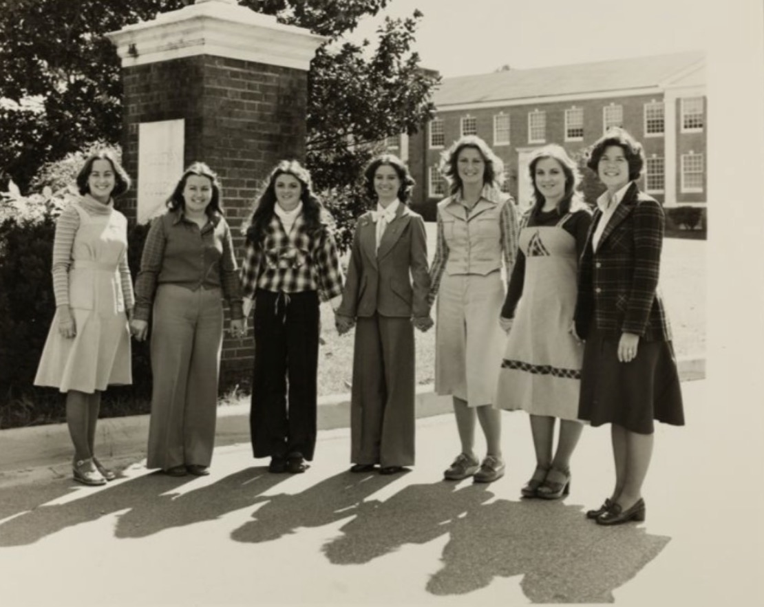 historical photo from about the 1970 of sisters holding hands posing for photo on campus