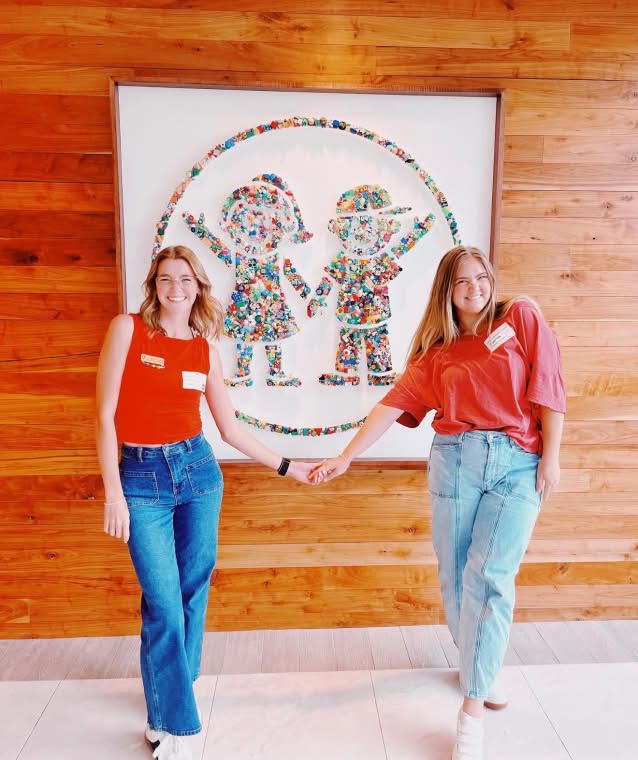 PMU-sister-posing-next-to-event-banner-childrens-miracle-network-small@2x