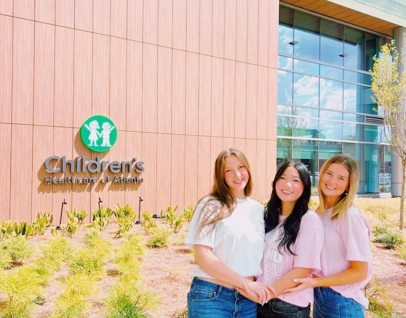 PMU-sisters-posing-outside-charity-building-childrens-miracle-network-banner@2x