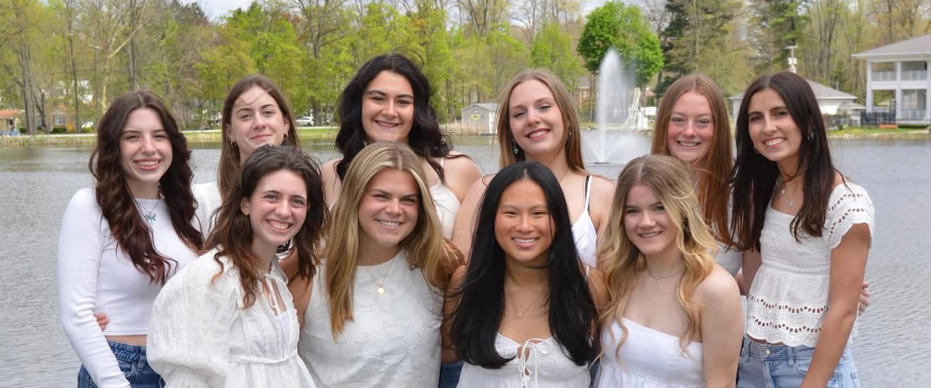 Group od girls posing for a photo infront of lake